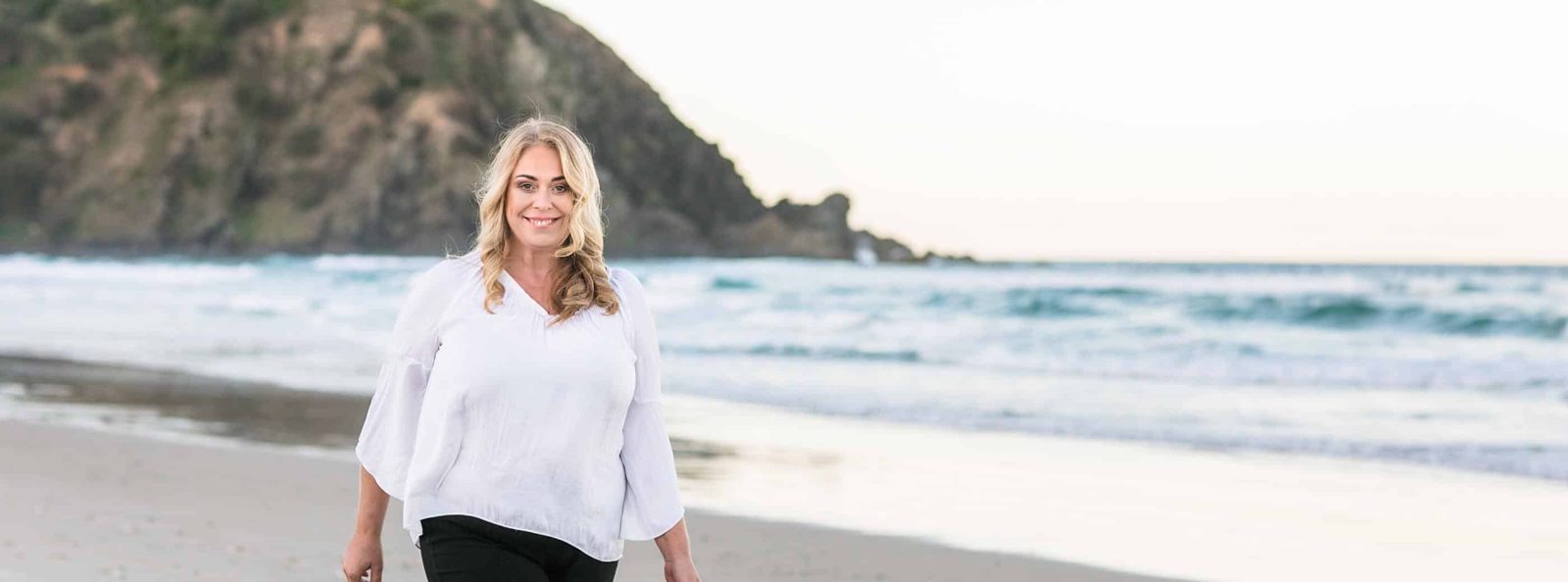 Jeanette Farren walking on the beach after selling DiggiddyDoggyDaycare to PETstock